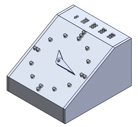 The image shows a solid model of the alarm clock. The front face is an analog clock face that typically are used by blind people. On the top of the clock is the novel alarm and time-setting buttons in which you can set the current time or the alarm using braille. The top of the clock includes space for four braille characters.